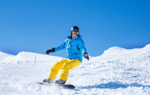 Beginner snowboarder riding down a sunny slope
