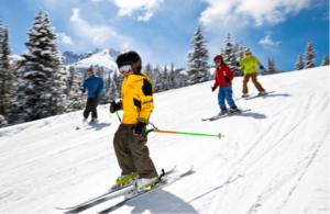 Kids skiing down a snowy slope with family in Utah